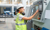 Industriansatt trykker på en skjerm.