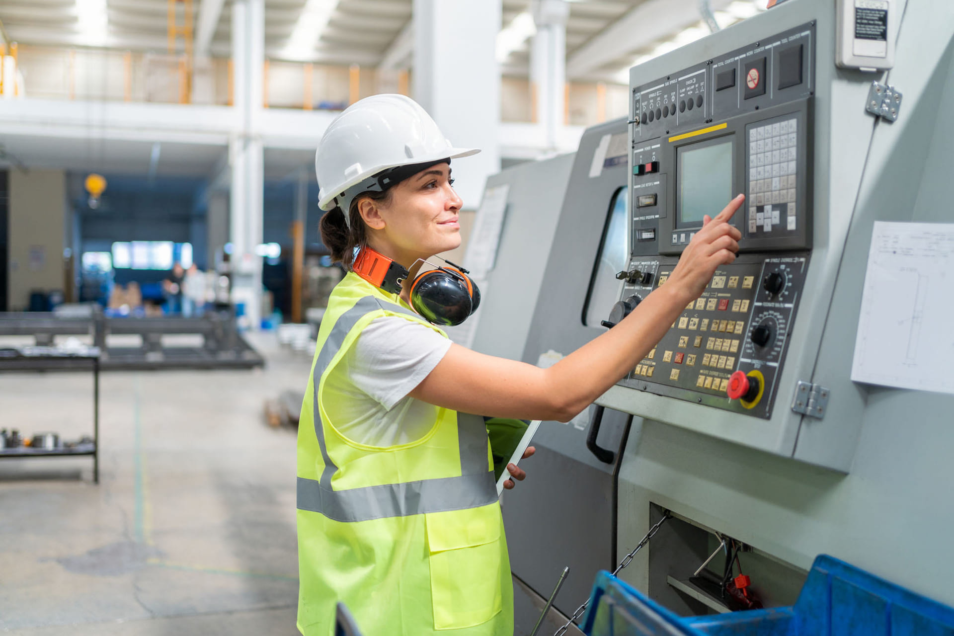 Industriansatt trykker på en skjerm.