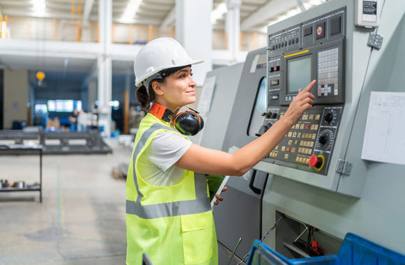 Industriansatt trykker på en skjerm.