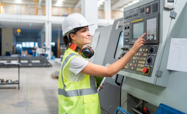 Industriansatt trykker på en skjerm.