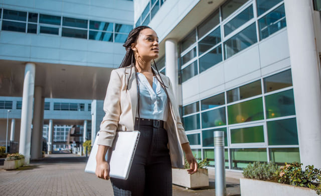 Kvinne går utenfor et kontorbygg