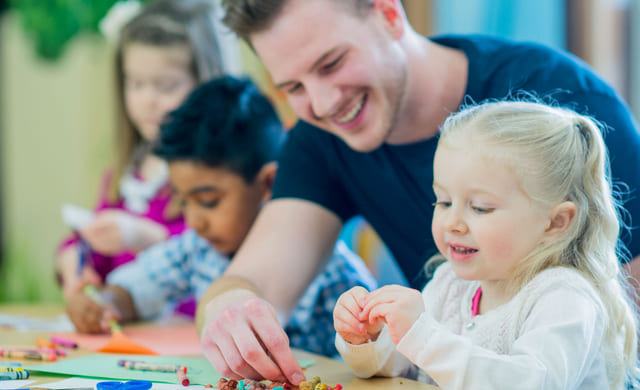 Voksen hjelper et barn på skolen