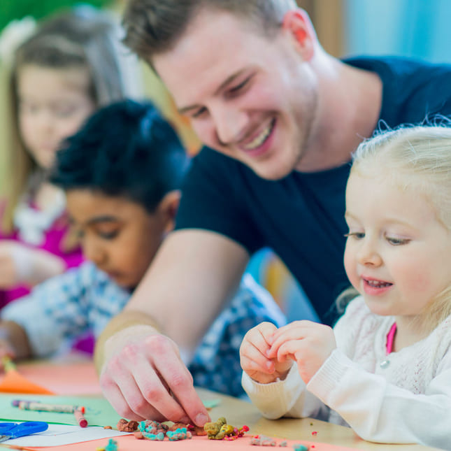 Voksen hjelper et barn på skolen