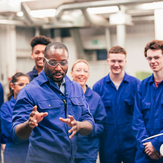 Gruppe mennesker med blå arbeidsdress på jobb