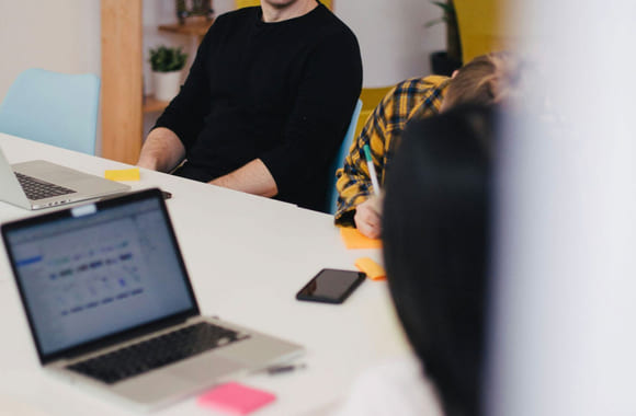 Kollegaer sitter i et fysisk møte på jobb.