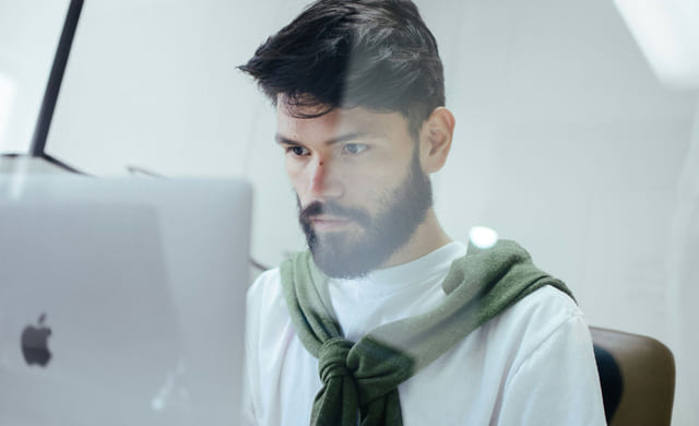 Mann jobber på en macbook