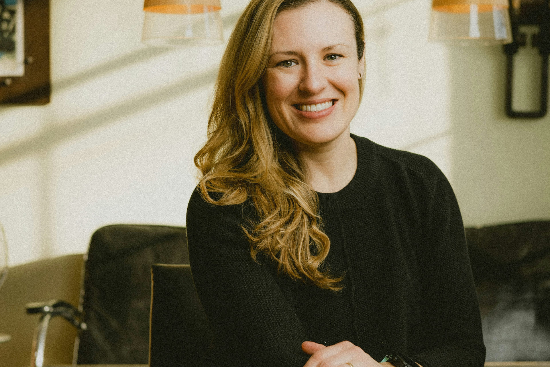 Kvinne i sort genser smiler