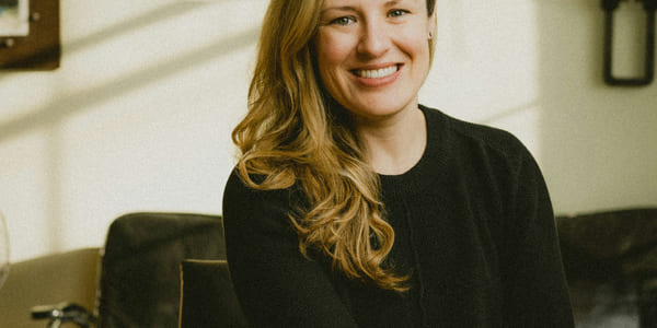 Kvinne i sort genser smiler